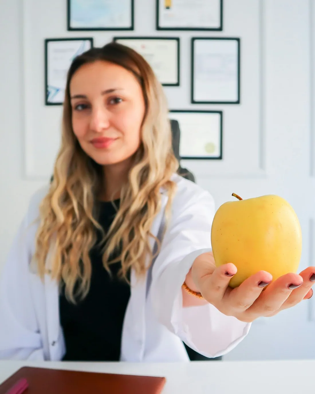 Diyetisyen Nehir Aksoy, Moda'daki kliniğinde elinde bir elmayla